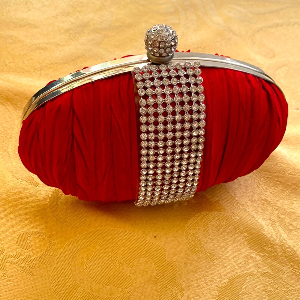 Red silk evening bag. Brand new. Never used. Has small chain handle.